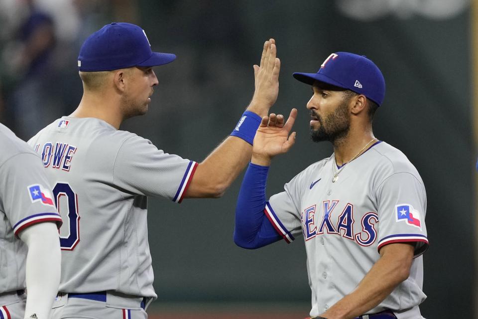Texas Rangers' Marcus Semien, right, celebrates with Nathaniel Lowe after a baseball game against the Houston Astros Sunday, April 16, 2023, in Houston. The Rangers won 9-1. (AP Photo/David J. Phillip)