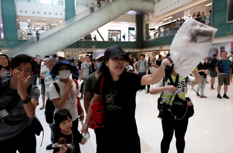 Shoppers and anti-government protesters gather at New Town Plaza in Sha Tin, Hong Kong