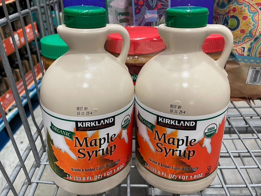 Two bottles of Kirkland organic maple syrup in a cart.