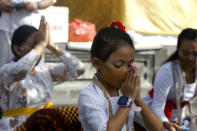 A Balinese girl wearing face mask prays at a temple amid concerns of the new coronavirus outbreak during a Hindu ritual in Bali, Indonesia Saturday, July 4, 2020. (AP Photo/Firdia Lisnawati)