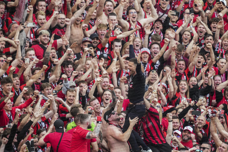 Leverkusen's head coach Xabi Alonso celebrates with fans as his team won the German Bundesliga, after the German Bundesliga soccer match between Bayer Leverkusen and FC Augsburg at the BayArena in Leverkusen, Germany, Saturday, May 18, 2024. Bayer Leverkusen have won the Bundesliga title for the first time. It is the first team in Bundesliga history, that won the championship unbeaten for the whole season. (AP Photo/Michael Probst)