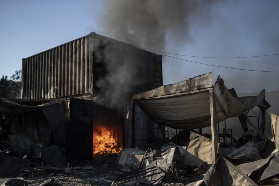 Flames burn a container in the Moria refugee camp on the northeastern island of Lesbos, Greece, Thursday, Sept. 10, 2020. A second fire in Greece's notoriously overcrowded Moria refugee camp destroyed nearly everything that had been spared in the original blaze, Greece's migration ministry said Thursday, leaving thousands more people in need of emergency housing. (AP Photo/Petros Giannakouris)