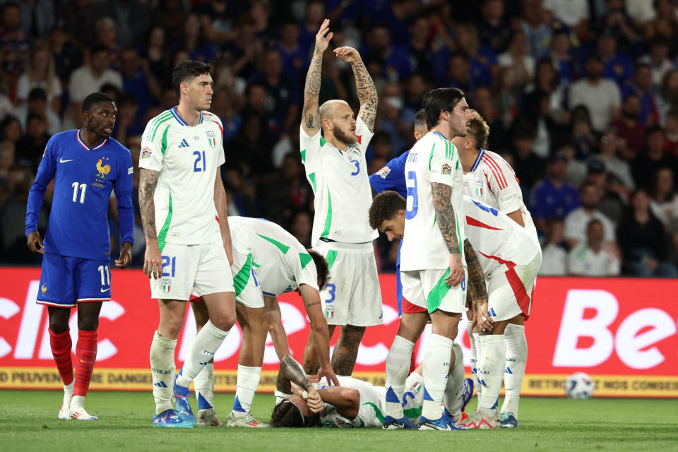 Italy's defender #03 Federico Dimarco (C) gestures as Italy's defender #05 Riccardo Calafiori lies on the football pitch during the UEFA Nations League Group A2 football match between France and Italy at the Parc des Princes in Paris on September 6, 2024. (Photo by FRANCK FIFE/AFP via Getty Images)