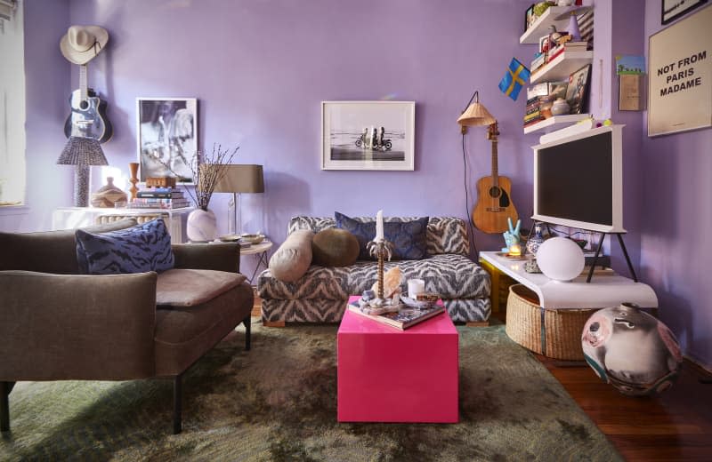 Love seat in eclectic purple living room.