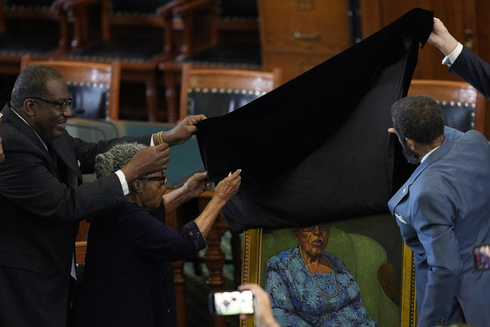 Opal Lee, who worked to help make Juneteenth a federally-recognized holiday, second from left, with state Sen. Royce West, left, helps unveil her portrait in the Texas Senate Chamber, Wednesday, Feb. 8, 2023, in Austin, Texas. (AP Photo/Eric Gay)