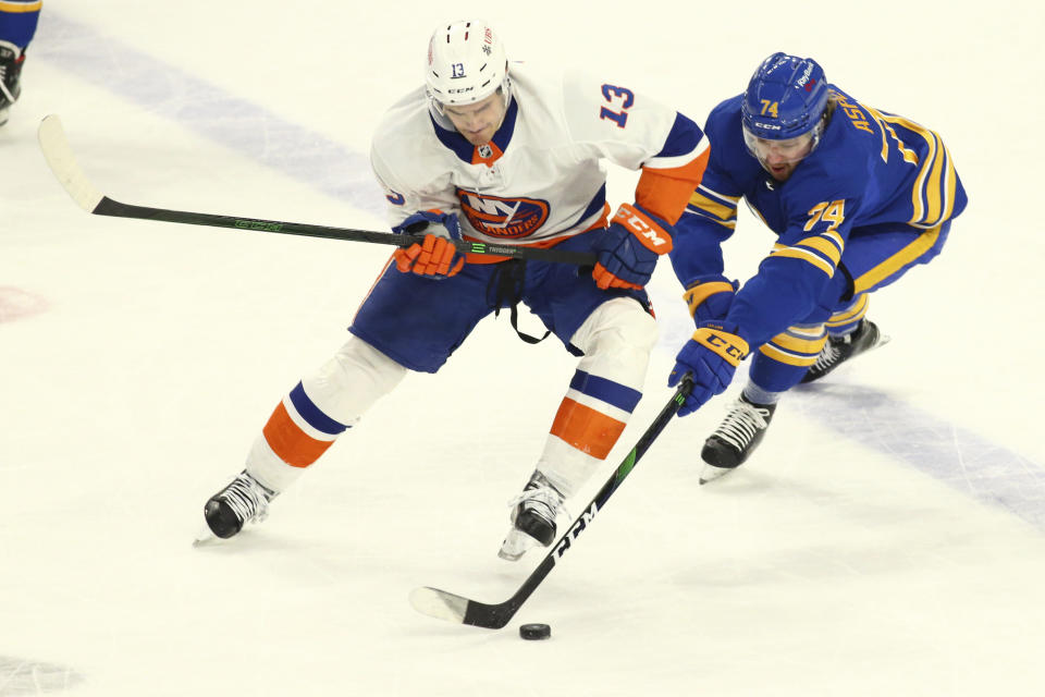 Buffalo Sabres forward Rasmus Asplund (74) losses the puck to New York Islanders forward Mathew Barzal (13) during the first period of an NHL hockey game, Monday, May 3, 2021, in Buffalo, N.Y. (AP Photo/Jeffrey T. Barnes)