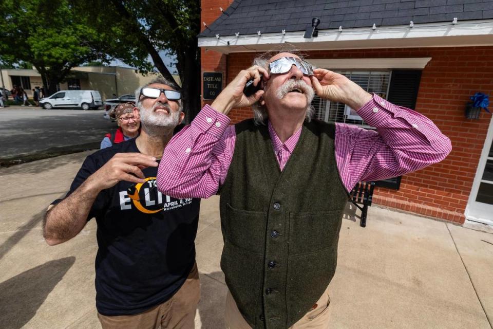 San Francisco resident Vahid Statuary, left, helps Seattle resident Dan Burden see through his homemade eclipse glasses prior to the Great North American Eclipse in Hillsboro on Monday, April 8, 2024.