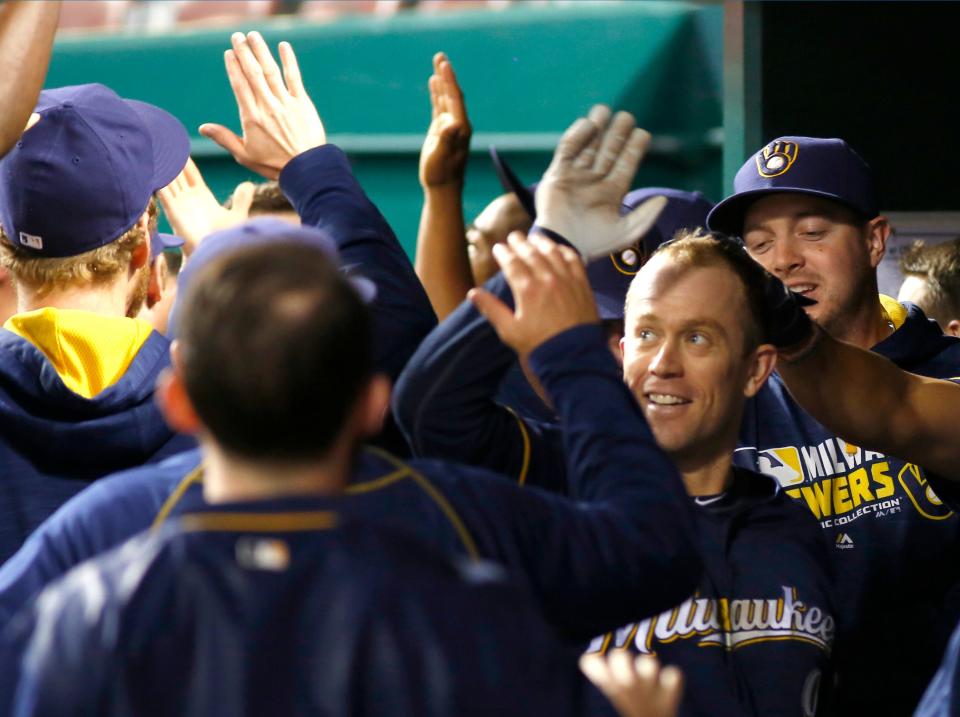 Milwaukee Brewers third baseman Aaron Hill (right) is congratulated by teammates after he hit a grand slam against the Cincinnati Reds during the tenth inning at Great American Ball Park on May 7, 2016. The Brewers won in ten innings 13-7.