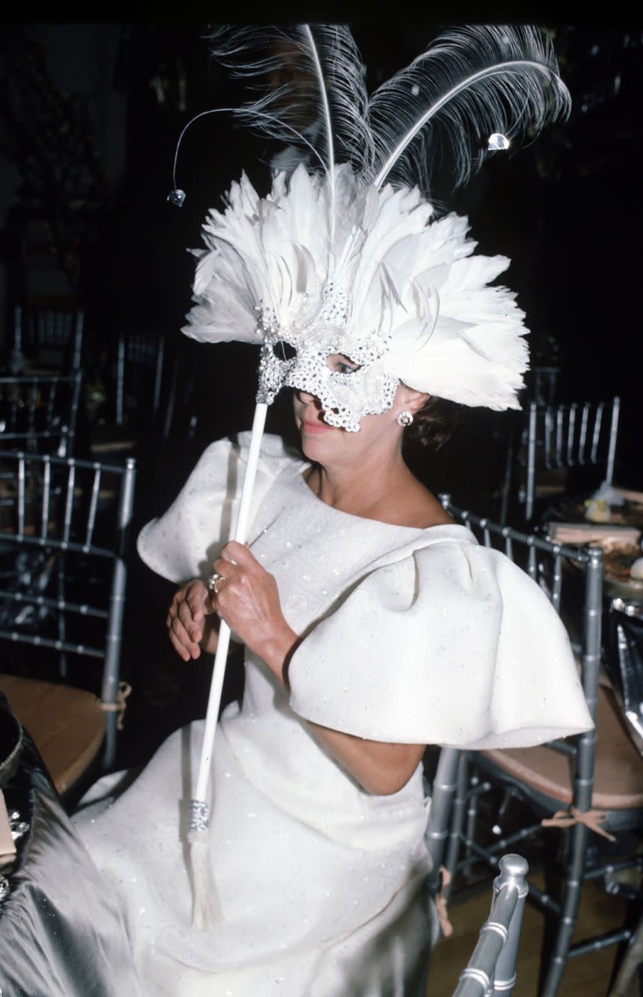 <p>The Princess wears an elaborate mask and matching white gown in 1990. </p>