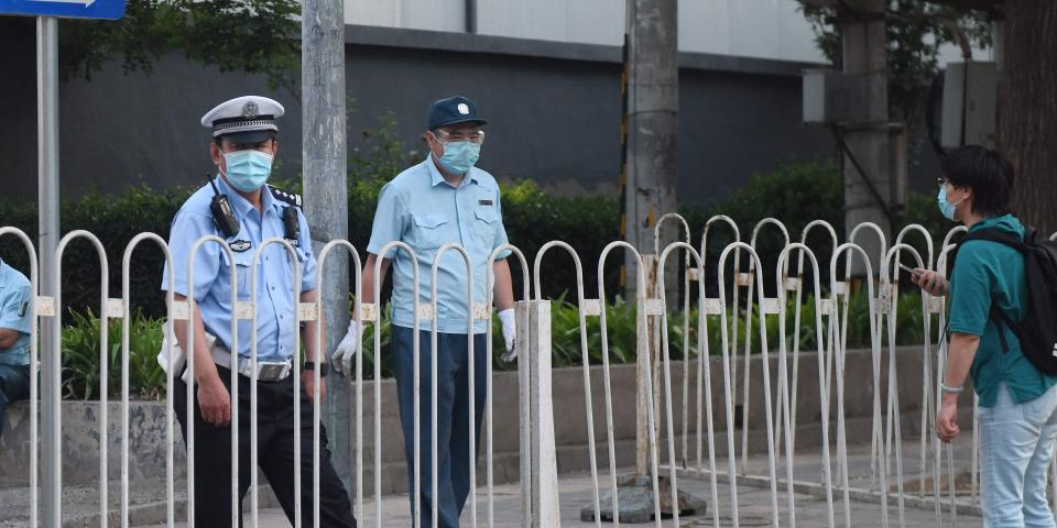 A policeman stands guard behind a barrier blocking the entrance to a closed off residential compound near the closed Xinfadi market in Beijing on June 13, 2020. - The huge wholesale market has become the centre of focus for a new cluster of coronavirus cases in Beijing, where nervous local officials have begun mass testing, closing schools and neighbourhoods, and turned sharp scrutiny towards the food supply chain. (Photo by GREG BAKER / AFP) (Photo by GREG BAKER/AFP via Getty Images)