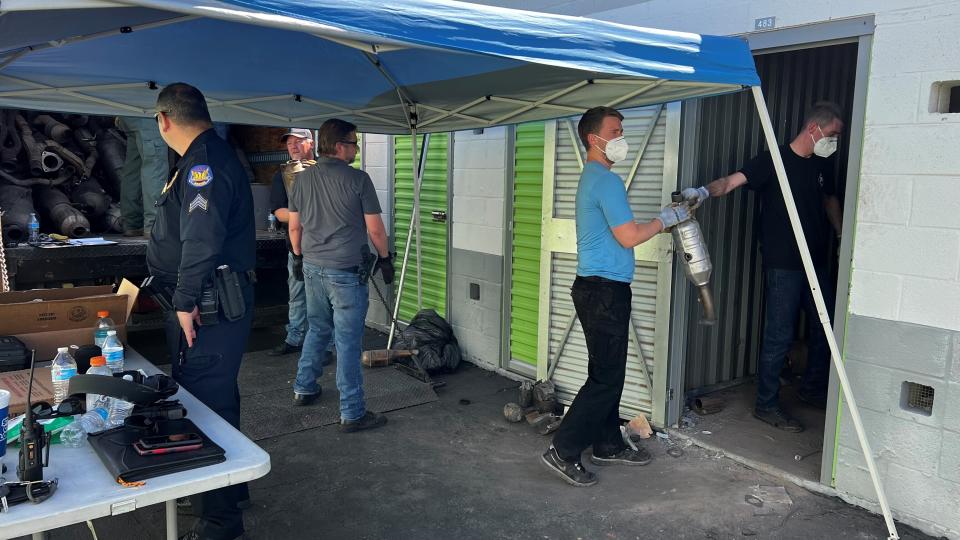 This photo provided by the Phoenix Police Department shows Phoenix police detectives work to recover more than 1,200 stolen catalytic converters after detectives served a search warrant at a storage unit in Phoenix on Thursday, May 27, 2022. They arrested Shelton Ford, a 48-year-old man not seen, on 40 counts of theft. The bust came amid a national surge in thefts of the pricy auto parts that play a critical in reducing vehicle emissions and has led lawmakers in 36 states and in Washington D.C. to consider new laws to address the problem. (Phoenix Police Department via AP)