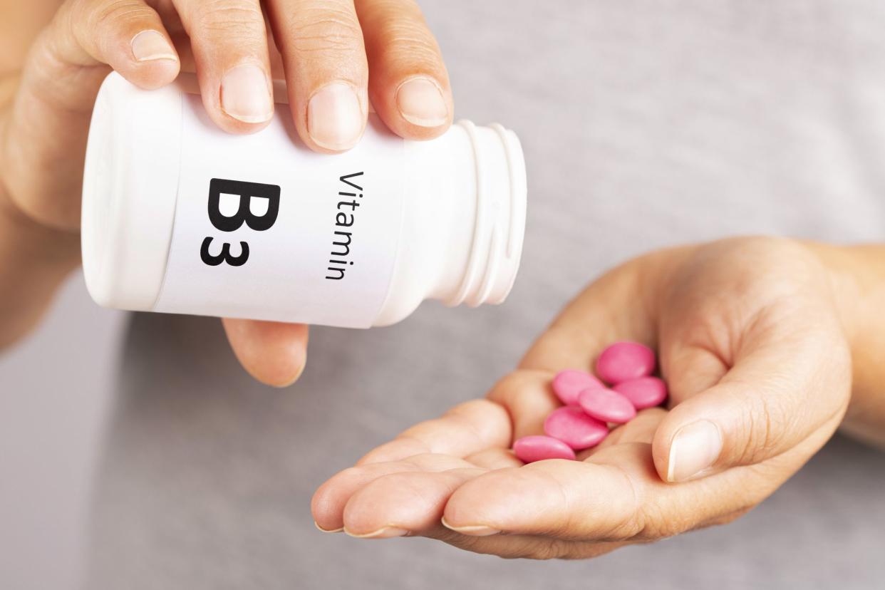 Woman hand takes vitamin B3  from medicine container