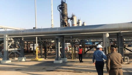 Workers are seen at the damaged site of Saudi Aramco oil facility in Abqaiq