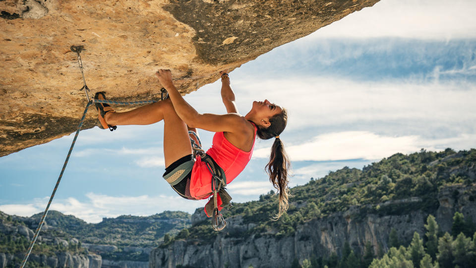 Young woman rock climbing in Margalef Catalonia Spain.