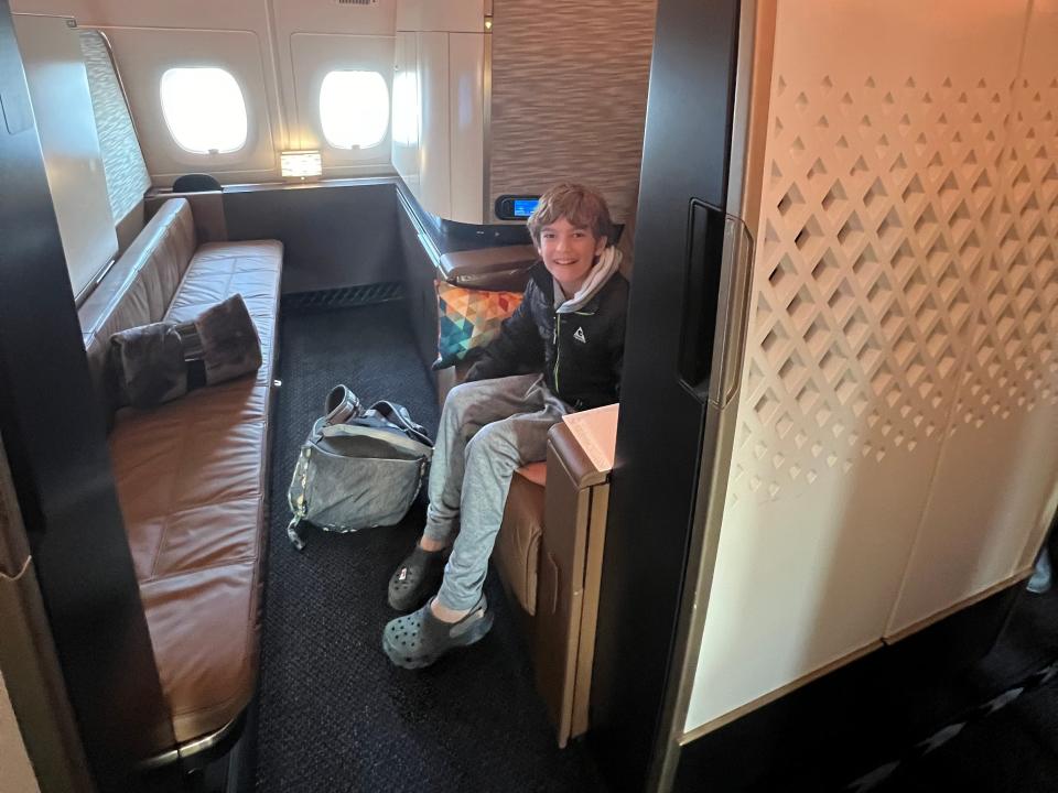 child sitting in a first class apartment seat on an etihad airways flight
