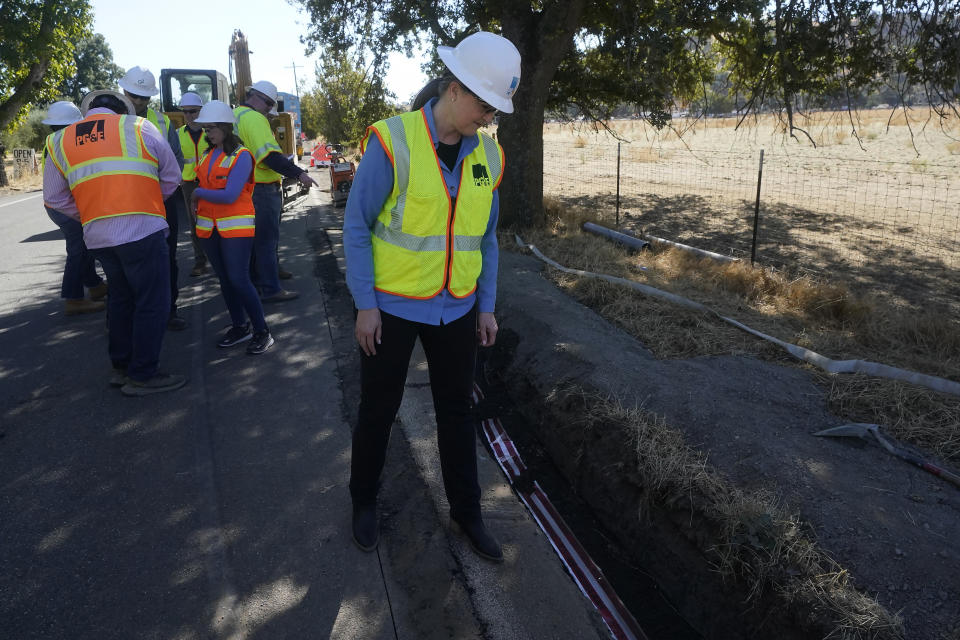 Pacific Gas and Electric CEO Patti Poppe looks down while being interviewed during a tour of PG&E workers burying power lines in Vacaville, Calif., Wednesday, Oct. 11, 2023. PG&E wants to bury many of its power lines in areas threatened by wildfires. (AP Photo/Jeff Chiu)