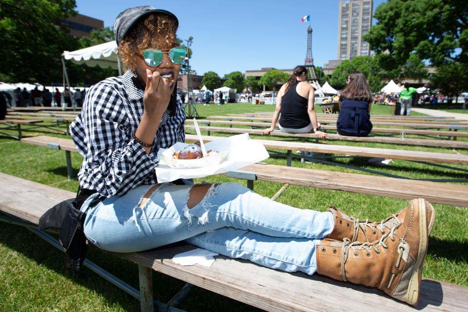 Kenya Evans enjoys a beignet during Bastille Days in Milwaukee, Wisconsin on Thursday, July 11, 2019.