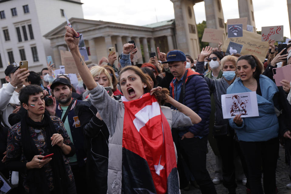 <b>Berlin, Germany</b> A female protester yells while cutting her hair with scissors as an act of solidarity with women in Iran during a demonstration on Sept. 23, 2022.<span class="copyright">Sean Gallup—Getty Images</span>