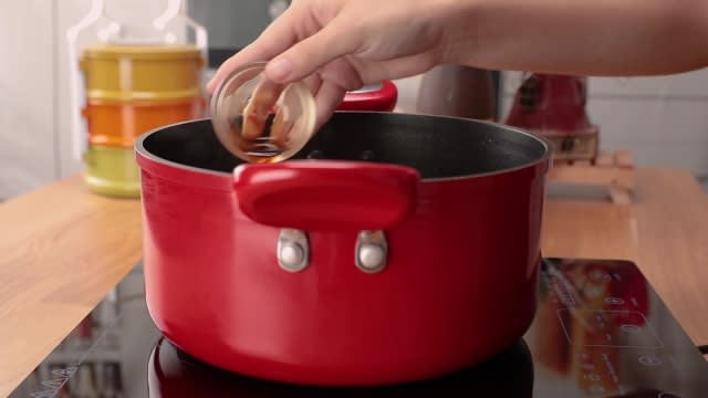 Pouring soya sauce into soup