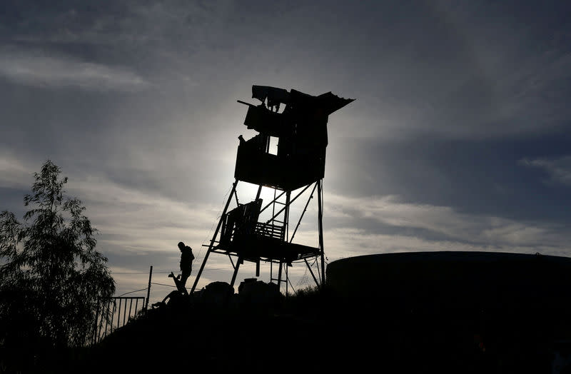 Un Palestinien inspecte une cible touchée par un raid aérien israélien dans le sud de la bande de Gaza. Les territoires palestiniens connaissent un regain de tension depuis la reconnaissance mercredi dernier par le président américain Donald Trump de Jérusalem comme capitale d'Israël. Deux Palestiniens du groupe Djihad islamique qui circulaient à moto dans la bande de Gaza ont été tués mardi. /Photo prise le 12 décembre 2017/REUTERS/Ibraheem Abu Mustafa