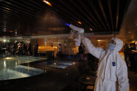 A staff member wearing protective suit sprays disinfectant on the spa facilities to help prevent the spread of COVID-19 as the massage parlor will be reopened, in Hong Kong, Thursday, Sept. 17, 2020. Government officials said that it would further relax social-distancing measures, allowing bars, amusement parks and swimming pools to re-open. (AP Photo/Kin Cheung)