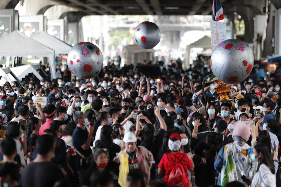 Large balls that depict asteroids are thrown in the air over a crowd attending a student rally in Bangkok, Saturday, Nov. 21, 2020. Organized by a group that mockingly calls themselves "Bad Students," the rally calls for educational reforms and also supports the broader pro-democracy movement's demands for constitutional change. (AP Photo/Sakchai Lalit)