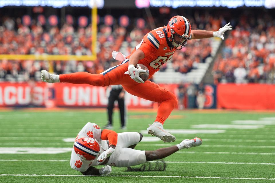 Syracuse tight end Dan Villari (89) jumps over Clemson cornerback Sheridan Jones (6) on his way to scoring a touchdown during the first half of an NCAA college football game in Syracuse on Saturday, Sept. 30, 2023. Clemson won 31-14.