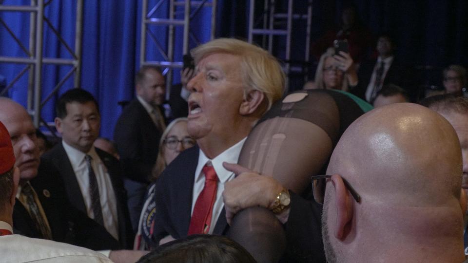 Borat (Sacha Baron Cohen) dresses up as Donald Trump and interrupts Mike Pence's CPAC speech in "Borat Subsequent Moviefilm."