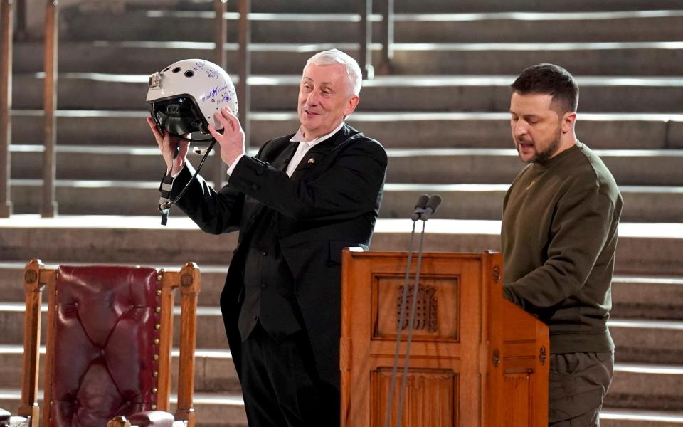 Speaker of the House of Commons, Sir Lindsay Hoyle, left, holds the helmet of one of the most successful Ukrainian pilots, inscribed with the words "We have freedom, give us wings to protect it", which was presented to him by Ukrainian President Volodymyr Zelensky - Stefan Rousseau/pool photo via AP