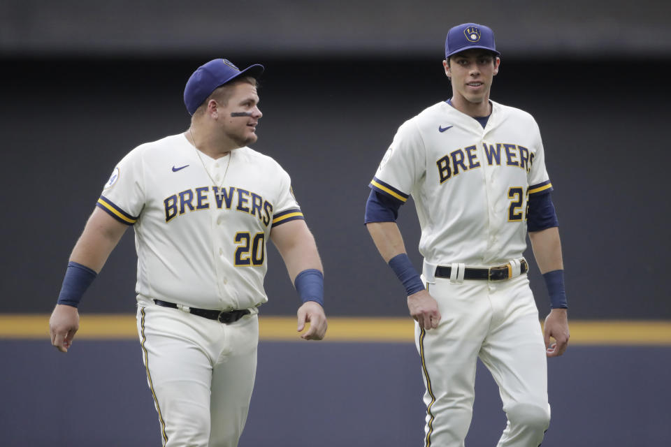 Milwaukee Brewers' Christian Yelich (22) and Daniel Vogelbach (20) warm up before a baseball game against the Cincinnati Reds Monday, June 14, 2021, in Milwaukee. (AP Photo/Aaron Gash)