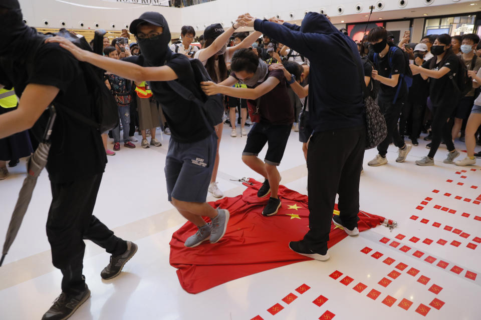 Protesters walk on a Chinese national flag during a protest at a mall in Hong Kong on Sunday, Sept. 22, 2019. Hong Kong's pro-democracy protests, now in their fourth month, have often descended into violence late in the day and at night. A hardcore group of protesters says the extreme actions are needed to get the government's attention. (AP Photo/Kin Cheung)