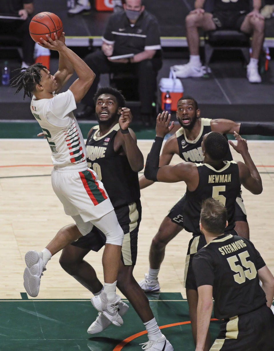 Miami guard Isaiah Wong (2) shoots over Purdue defenders during the first half of an NCAA college basketball game Tuesday, Dec. 8, 2020, in Coral Gables, Fla. (Al Diaz/Miami Herald via AP)