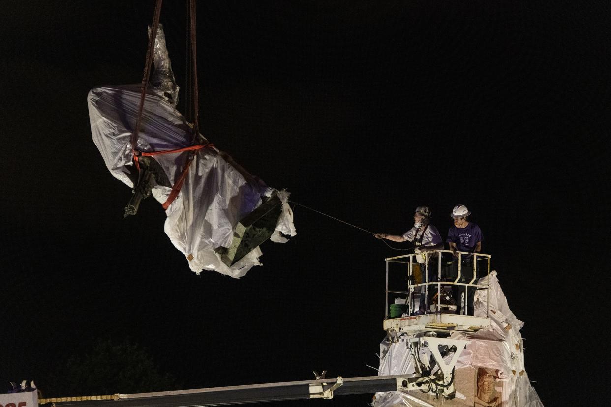 City municipal crews help guide a Christopher Columbus statue in Grant Park down as it is removed by a crane on July 24, 2020 in Chicago. The statue of Christopher Columbus that drew protests in Chicago was taken down early Friday amid a plan by President Donald Trump to dispatch federal agents to the city.