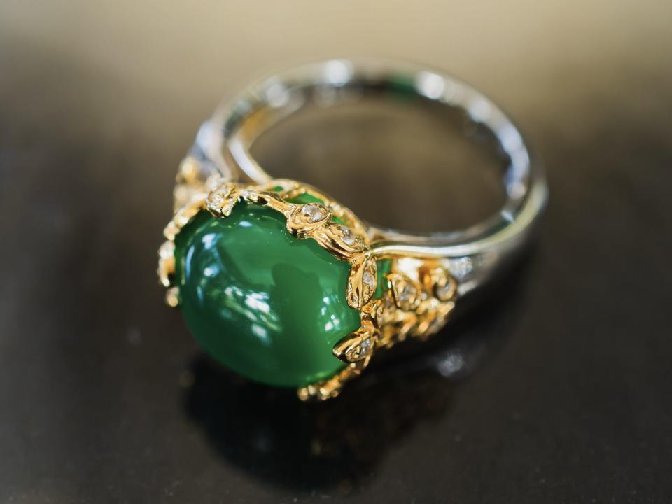 gold and silver with with green jewel lying on counter
