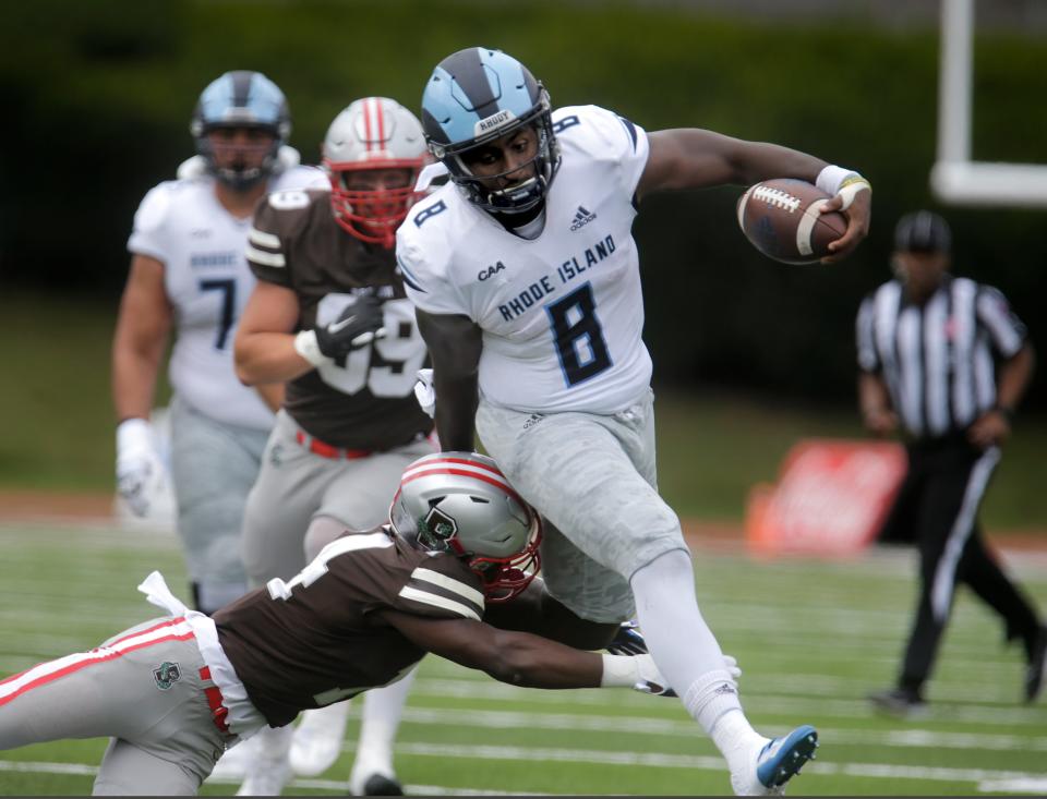 URI quarterback Kasim Hill, who has received recognition this spring in preseason all-conference teams, dodges a tackle during the Governor's Cup game against the Bears last September at Brown Stadium.