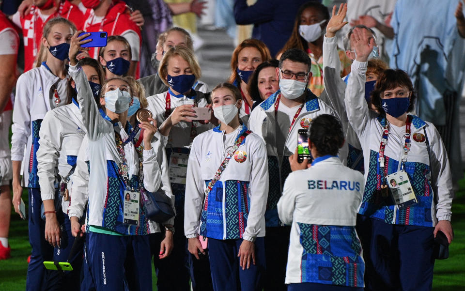 Athletes of Belarus' delegation take selfie photographs during the closing ceremony of the Tokyo 2020 Olympic Games, on August 8, 2021 at the Olympic Stadium in Tokyo. (Photo by Oli SCARFF / AFP) (Photo by OLI SCARFF/AFP via Getty Images)