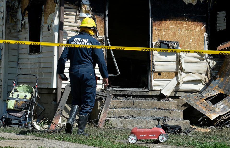 Erie Bureau of Fire Inspector Mark Polanski works at the scene of a fatal house fire on Sunday in Erie, Pa.