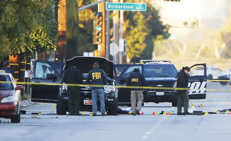 FBI and police investigator are seen around a vehicle in which two suspects were shot following a mass shooting in San Bernardino, California December 3, 2015. REUTERS/Mike Blake