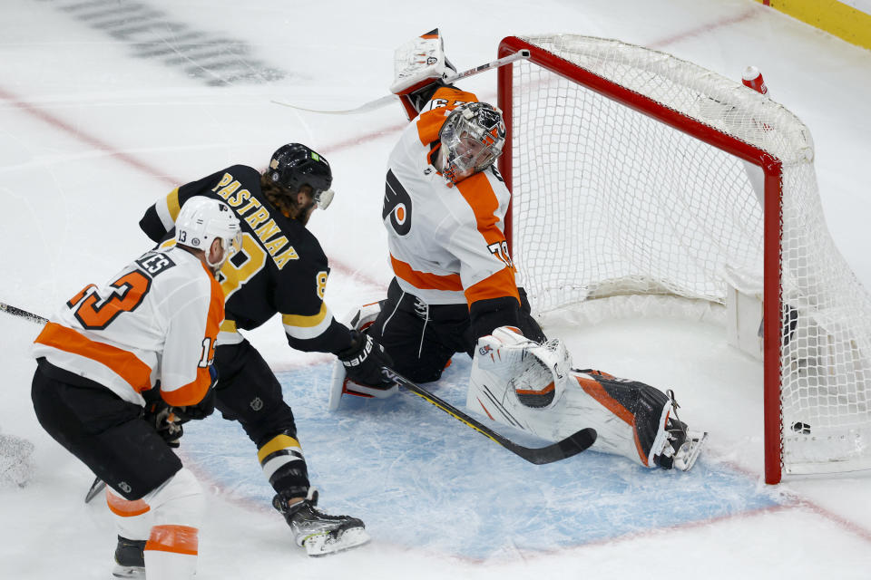 Boston Bruins right wing David Pastrnak scores past Philadelphia Flyers goaltender Carter Hart and center Kevin Hayes during the first period of an NHL hockey game, Monday, Jan. 16, 2023, in Boston. (AP Photo/Mary Schwalm)