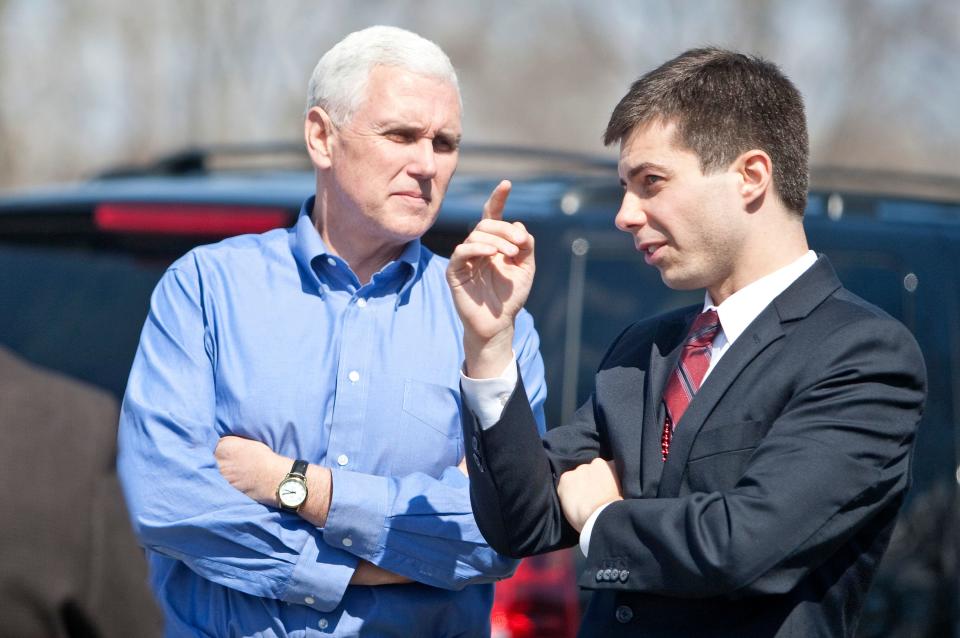 In this April 1, 2013 photo, Indiana Gov. Mike Pence, left, speaks to South Bend Mayor Pete Buttigieg following a Dyngus Day event in South Bend, Ind.