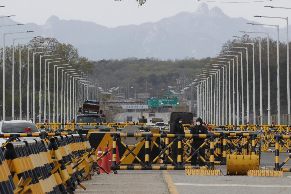 South Korean army soldiers wearing protective suits stand guard at the Unification Bridge, which leads to the Panmunjom in the Demilitarized Zone in Paju, South Korea, Tuesday, April 21, 2020. The South Korean government said Tuesday no unusual activity has been detected in North Korea after unconfirmed reports described leader Kim Jong Un as in fragile condition after heart surgery. (AP Photo/Ahn Young-joon)