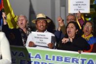 Demonstrators hold signs reading "We are sovereign [state], not a colony" as they shout slogans outside the British Embassy in Quito on August 15, 2012