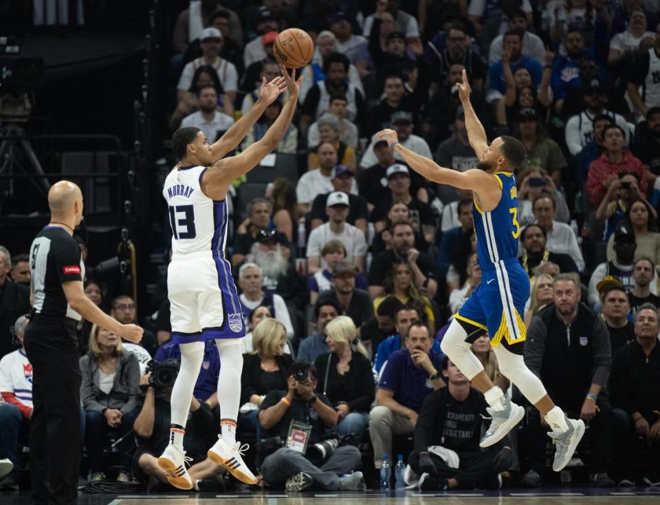 Sacramento Kings forward Keegan Murray (13) shoots a basket over Golden State Warriors guard Stephen Curry (30) during a NBA play-in game at Golden 1 Center on Tuesday, April 16, 2024.