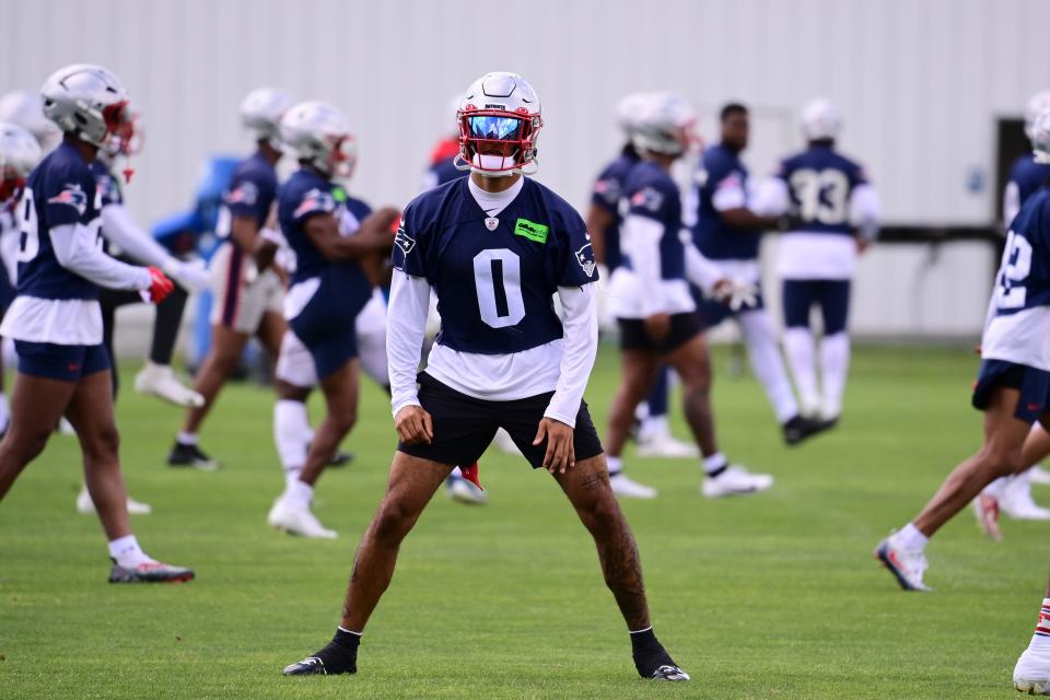 Patriots second-year cornerback Christian Gonzalez stretches before practice at minicamp on Monday.