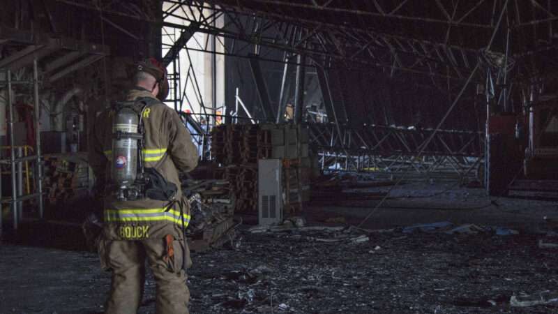 Firefighter stands in burnt out building