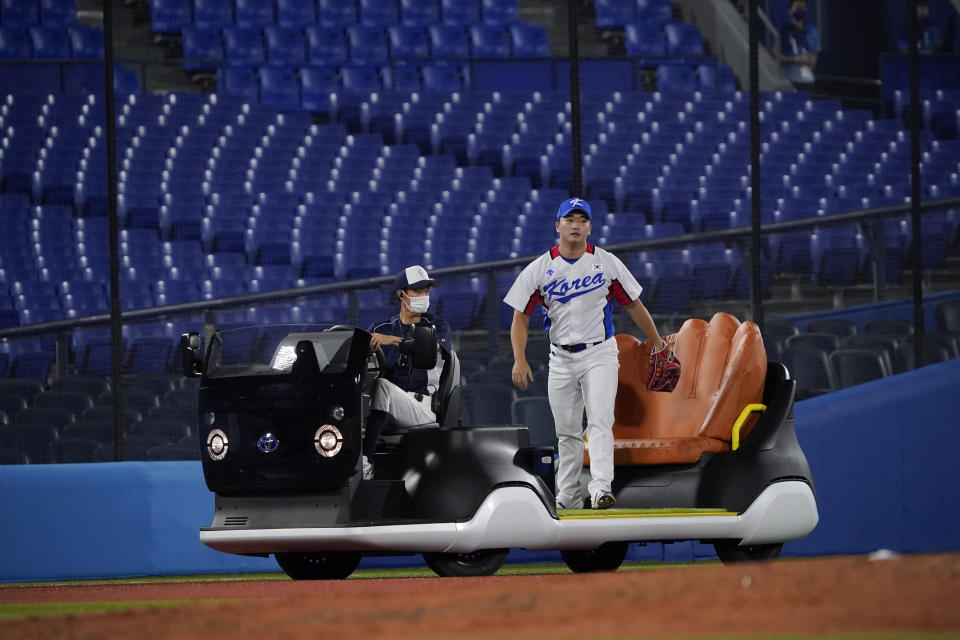 South Korea's Woosuk Go arrives to pitch in the seventh inning of a baseball game against the Dominican Republic at the 2020 Summer Olympics, Sunday, Aug. 1, 2021, in Yokohama, Japan. (AP Photo/Sue Ogrocki)