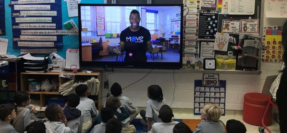 Elementary school students in New York City, in a photo taken before the coronavirus pandemic closed schools, start their day by following along with a Move This World video.