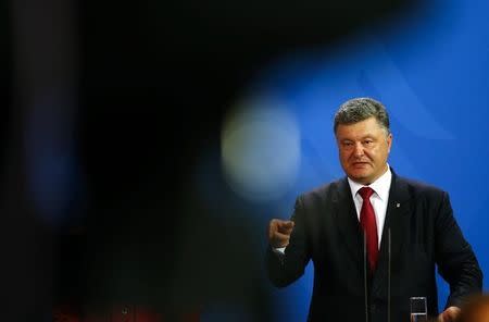 Ukrainian President Petro Poroshenko speaks to media after a meeting with French President Francois Hollande and German Chancellor Angela Merkel in the Chancellery in Berlin, Germany, August 24, 2015. REUTERS/Axel Schmidt