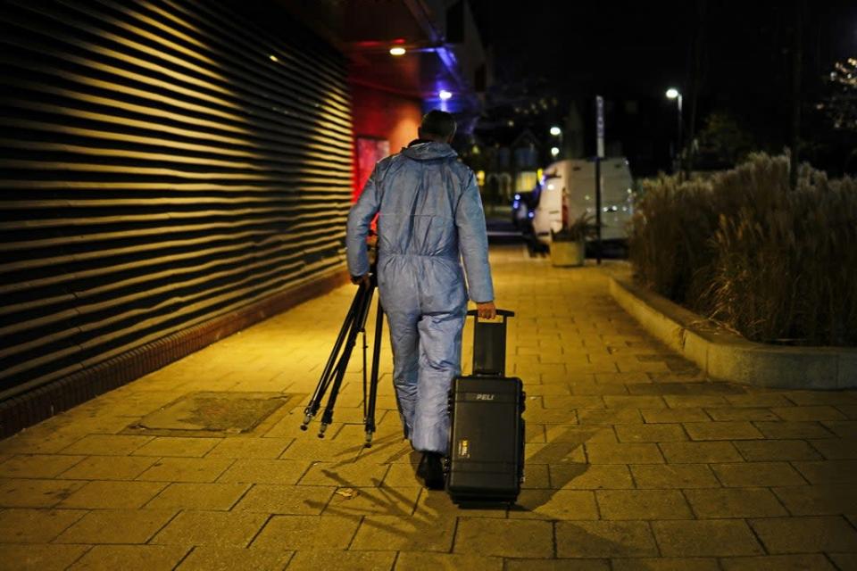 A forensic officer emerges from the property in Mayes Road (PA)