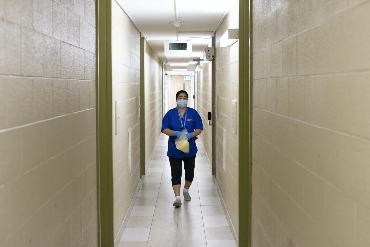 <span class="caption">A personal support worker with West Neighbourhood House's Parkdale Assisted Living Program on her way to see a resident at Toronto's May Robinson apartments seniors' housing on April 17 2020. </span> <span class="attribution"><span class="source">THE CANADIAN PRESS/Chris Young</span></span>